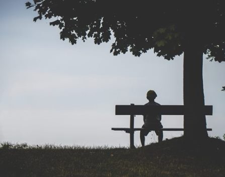 Picture of person sitting on a bench contemplating