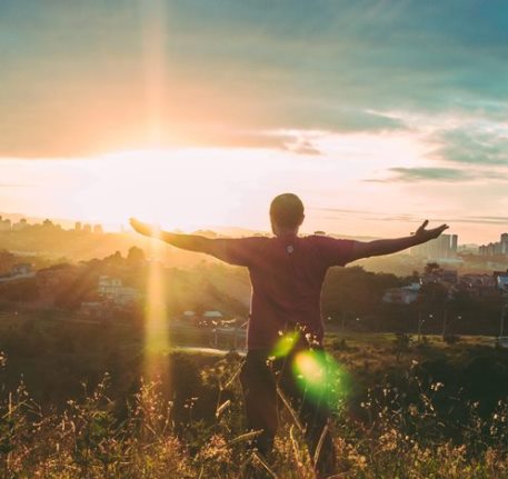 Picture of man holding his arms out to the sunset